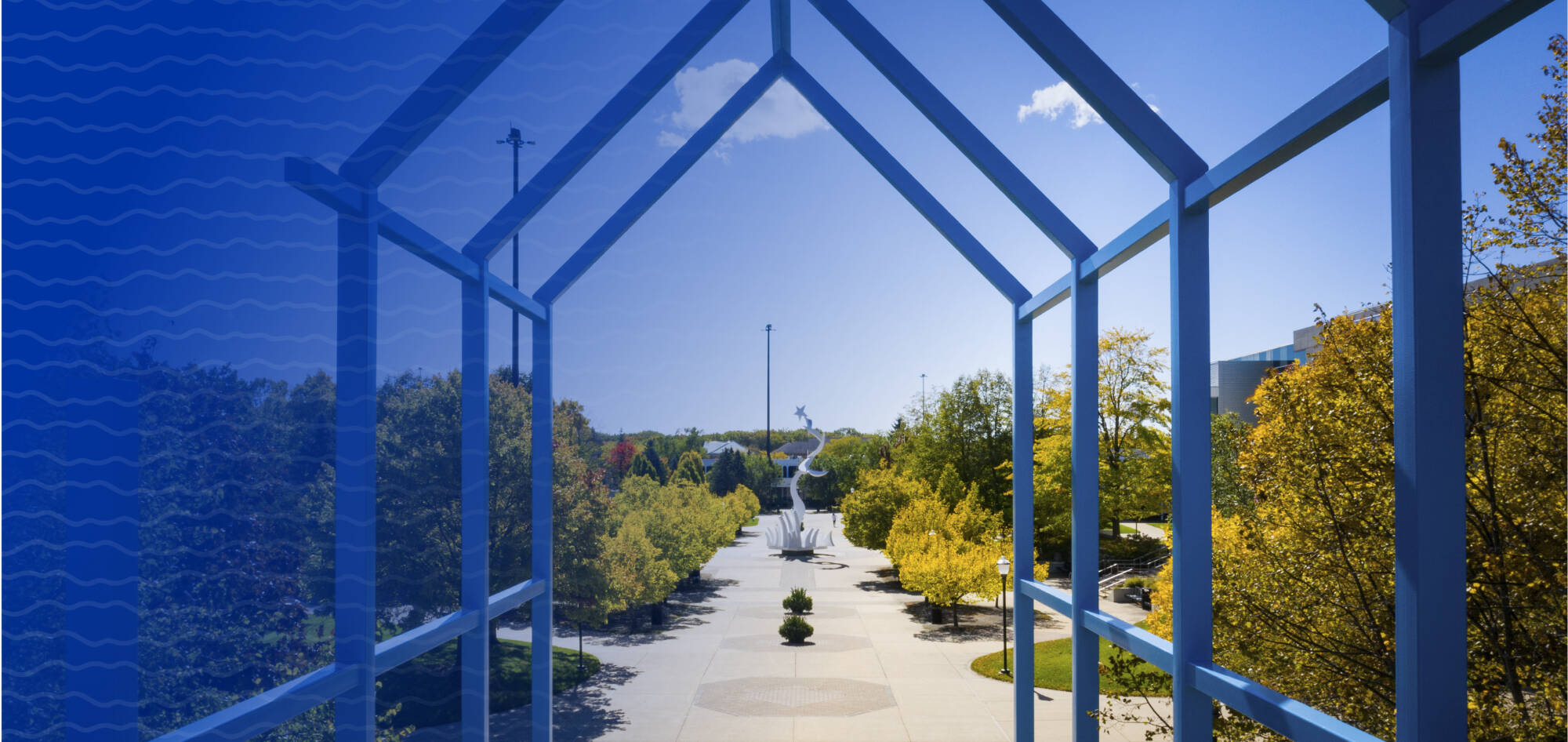 A photo of the transformational link on the Valley campus with the wave pattern and a blue gradient subtly overlaying the photo.